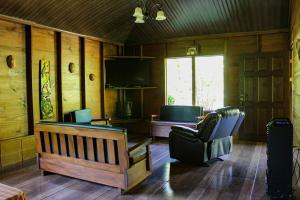 a living room with a couch and a chair and a television at Quinta La Carmencita in Santa Elena