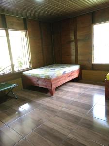 a bedroom with a bed in a room with windows at Quinta La Carmencita in Santa Elena