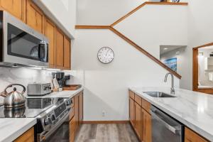 a kitchen with a sink and a clock on the wall at Los Pinos 22C by Great Western Lodging in Breckenridge