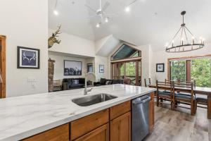 a kitchen with a sink and a living room at Los Pinos 22C by Great Western Lodging in Breckenridge