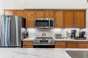 a kitchen with stainless steel appliances and wooden cabinets at Los Pinos 22C by Great Western Lodging in Breckenridge