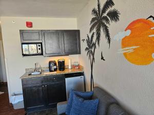 a kitchen with a palm tree stenciled on the wall at Oceanview Room at Landmark Resort in Myrtle Beach +39 photos