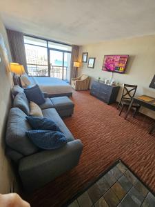 a living room with a couch and a bed at Oceanview Room at Landmark Resort in Myrtle Beach