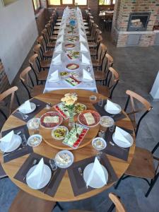a long table with plates of food on it at Seosko domaćinstvo Kastratović in Berane