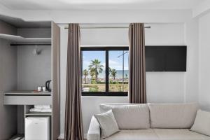 a living room with a couch and a window at Casa Del Sol Seaside Hotel in Durrës