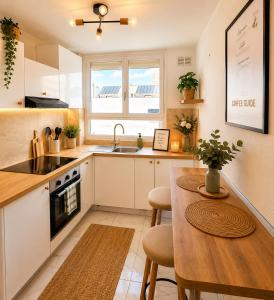 a kitchen with a table and a sink and a stove at Le cocon du lac in Montargis