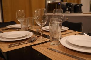 a table with wine glasses and plates and silverware at La Parenthèse Saint-Etienne- Nevers in Nevers +13 photos