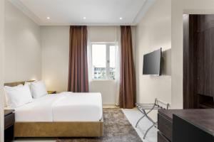 a hotel room with a bed and a television at Metro Apartments in Lagos +3 photos