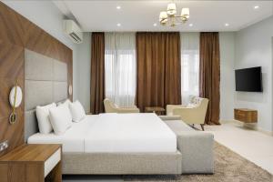 a bedroom with a white bed and a couch at Metro Apartments in Lagos