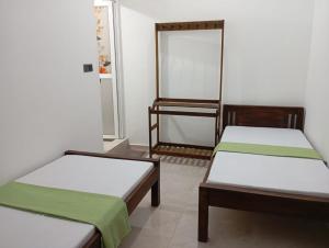 a room with two beds and a mirror at East HOME Kalmunai in Kalmunai