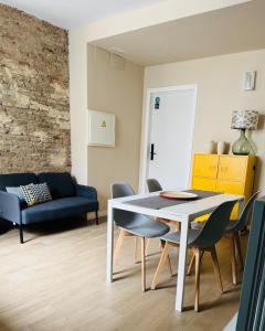 a living room with a table and chairs and a couch at Alegoría Coliving Experience in Seville