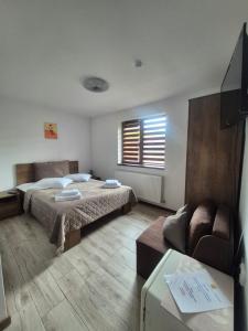 a bedroom with a bed and a couch at Casa Anima Călimănești Căciulata in Călimăneşti