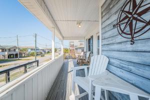 a porch with two white chairs on a house at Turtle-ly Beachin' - KDH MP 6, Ocean View, Beach 165 Yds, Sound Access, Year Round Flex Stays in Kill Devil Hills