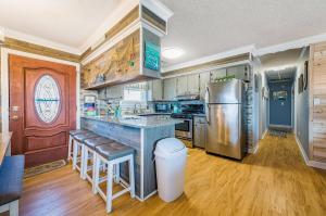 a kitchen with a stainless steel refrigerator and a counter at Turtle-ly Beachin' - KDH MP 6, Ocean View, Beach 165 Yds, Sound Access, Year Round Flex Stays in Kill Devil Hills