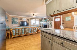 a kitchen with a counter top and a living room at Turtle-ly Beachin' - KDH MP 6, Ocean View, Beach 165 Yds, Sound Access, Year Round Flex Stays in Kill Devil Hills