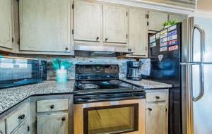 a kitchen with a stove and a refrigerator at Turtle-ly Beachin' - KDH MP 6, Ocean View, Beach 165 Yds, Sound Access, Year Round Flex Stays in Kill Devil Hills +51 photos