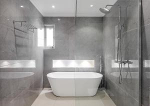 a bathroom with a white tub and a shower at Metro Apartments in Lagos