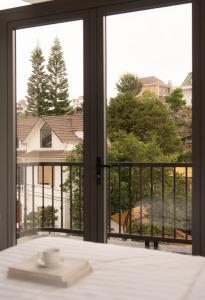 a room with a window with a view of a house at Velora Hotel DaLat in Xuan An