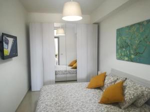 a bedroom with a bed with two yellow pillows at Sikelia home in Giardini Naxos