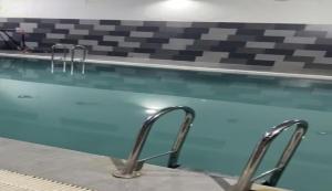 a swimming pool with two metal rails next to it at Magnifique Appartement Inès complexe Aida village in Tangier