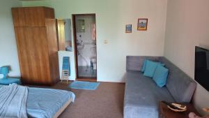 a living room with a couch and a television at Regina's Guesthouse in Balchik