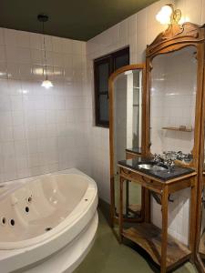 a bathroom with a bath tub and a sink at Cuatro Cerros Hostel in San Carlos de Bariloche +41 photos