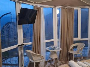a room with a large window with a table and chairs at Akho Panorama in Batumi