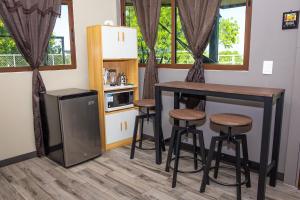 a kitchen with a table and stools and a counter at Cozy Cabin in Cumbres del Nacimiento, La Unión Sur in Conchagua