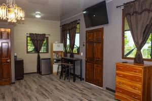 a living room with a kitchen with a table and a desk at Cozy Cabin in Cumbres del Nacimiento, La Unión Sur in Conchagua