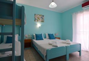 a bedroom with blue walls and a bed and a bunk bed at El Greco Nei Pori in Nei Poroi +42 photos
