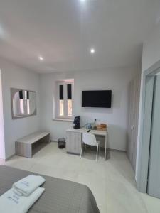 a bedroom with a bed and a desk and a television at Terra e Cielo Rooms in Parghelia