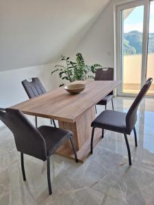 a wooden table with two chairs and a bowl on top at App TI-SA in Laze v Tuhinju