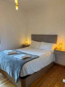 a bedroom with a large bed with two towels on it at Chalet do Médico in Rodeiro
