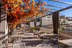 an outdoor patio with tables and chairs and flowers at Turia Badajoz in Badajoz