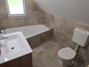 a bathroom with a white sink and a toilet at App TI-SA in Laze v Tuhinju +8 photos