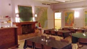 una classe con tavoli, sedie e un camino di Gafsele Lappland Hostel a Väster Gafsele
