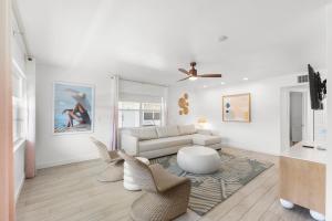 a white living room with a couch and chairs at Hotel Cabana Clearwater Beach in Clearwater Beach