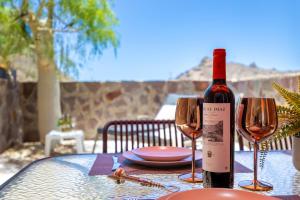 a bottle of wine sitting on a table with two glasses at Casa Ocean Love Sea View Duplex Tauro Golf in Mogán