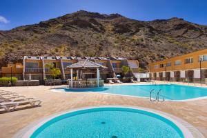 a pool at a hotel with a mountain in the background at Casa Ocean Love Sea View Duplex Tauro Golf in Mogán