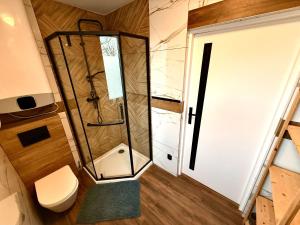 a small bathroom with a shower and a toilet at Niebieska Stodoła Karkonoska in Podgórzyn