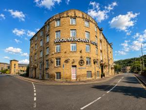 a large brick building with a sign on it at Wool Merchant Hotel HALIFAX in Halifax