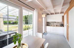a kitchen and dining room with a table and a large window at Domki Nad Morzem Babki z Piasku Dziwnów in Dziwnów +18 photos