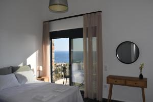a bedroom with a bed and a view of the ocean at Μαυρόλιθος in Karistos +34 photos
