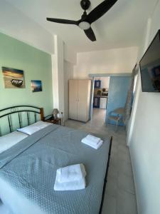 a bedroom with a bed and a ceiling fan at Hotel Glaros Lipsi in Leipsoi