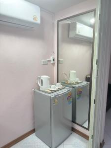 a small kitchen with a refrigerator and a mirror at Baan Kalaya Homestay in Nonthaburi +68 photos