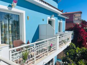 a balcony of a house with blue walls and plants at HELEN STUDIOS in Planos