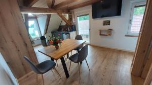 ein Esszimmer mit einem Holztisch und Stühlen in der Unterkunft Oderlandblick Apartment in Friedersdorf
