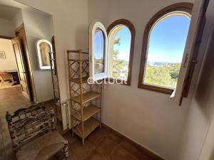 a room with three arched windows and a staircase at Casa Torrebosca 43 in Platja d'Aro +39 photos