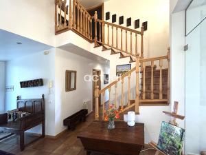 a living room with a staircase and a table at Casa Torrebosca 43 in Platja d'Aro