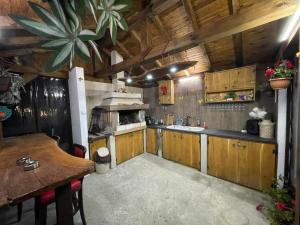 a kitchen with wooden cabinets and a wooden table at къща за гости Горски чар in Beli Osŭm